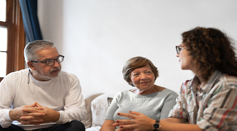 An older couple and their daughter having a conversation. The parents are listening