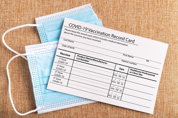 two face masks and a COVID-19 vaccination card