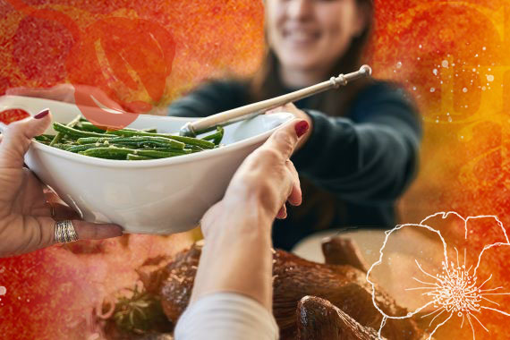 photo of a woman passing a bowl of green beans at a dinner table