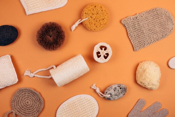 flat-lay photo of multiple loofahs and exfoliating gloves