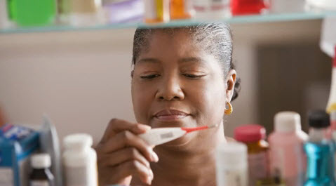 Woman looking through her medicine cabinet.