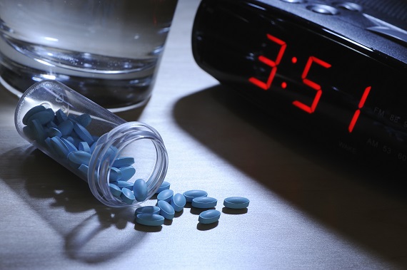 blue sleeping pills next to a digital clock that reads 3:51