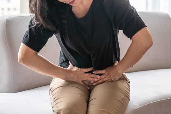 woman clutching her lower abdomen in pain