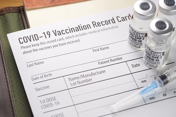 photo of COVID-19 vaccination card with vaccine vials and a syringe