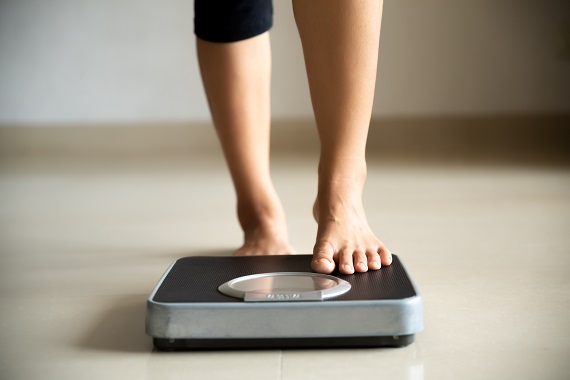woman stepping one foot onto a scale