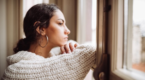 young woman looking out window