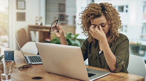 Woman tired at her desk at work.