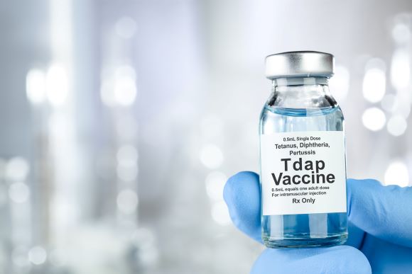 photo of a person holding a vial of a Tdap vaccine