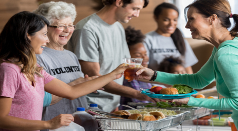 A volunteer handing out a Thanksgiving dinner for charity.