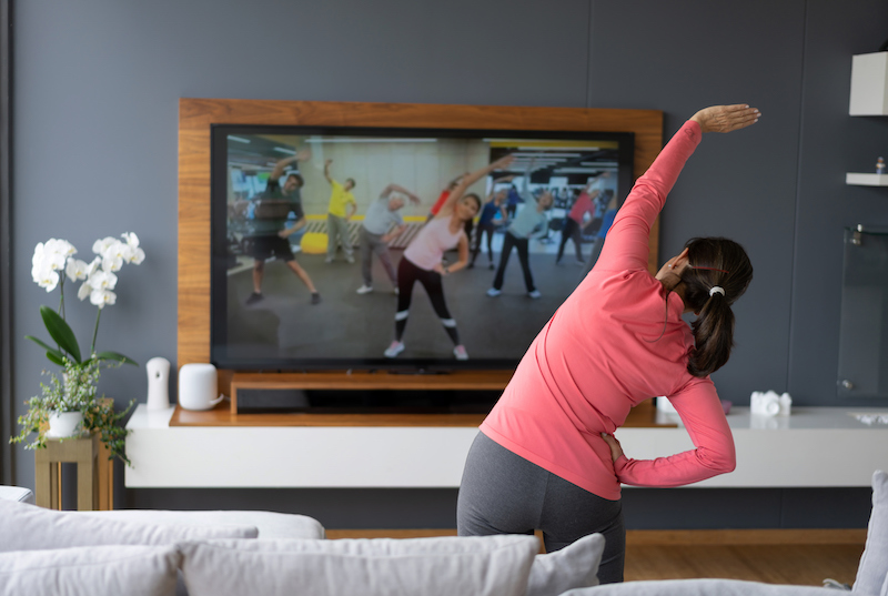 A woman works out with an online fitness class.