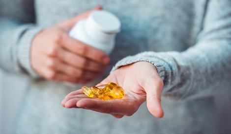 Customer holding fish oil supplements.