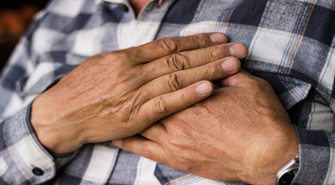 Hands holding chest because of heart pain. 