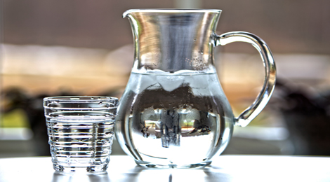 A pitcher and glass of water. 