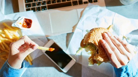 Eating burger and fries on the couch.