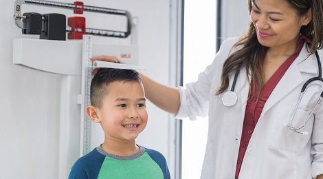 Doctor measuring a kid's height at his annual checkup.