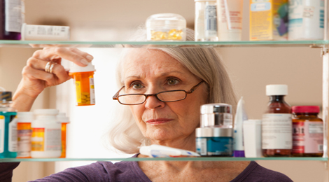 A woman checking the date on her prescribed medications. 