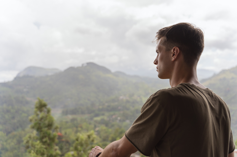 A man meditates alone in the forest. 