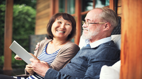 An elderly couple sitting on their porch. 