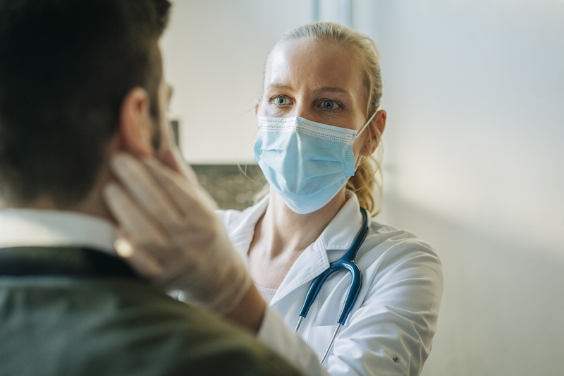 A doctor in a mask performs an exam.