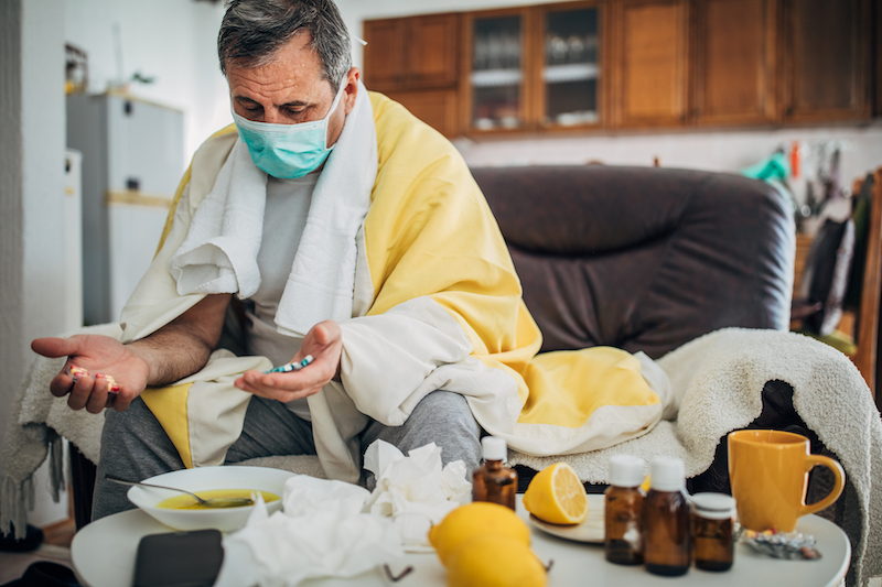 A sick man wears a mask at home. 