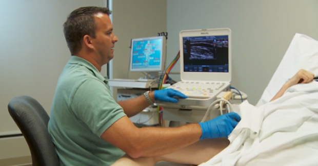 A doctor checking out a woman's varicose veins.