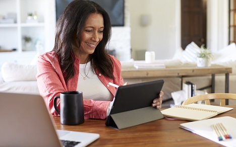 woman working on tablet from dining room table