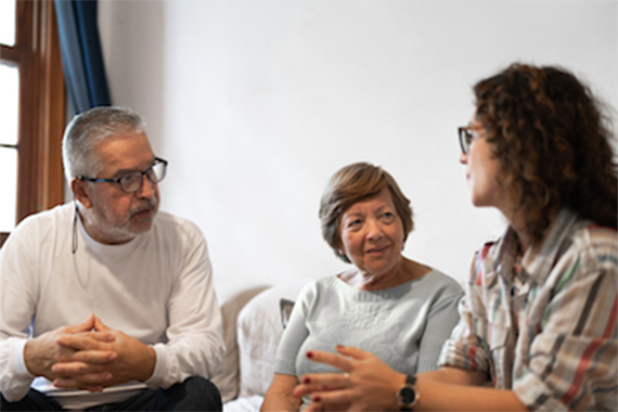 An older couple and their daughter having a conversation. The parents are listening