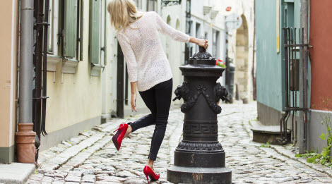 Women fixing her high heels on the street