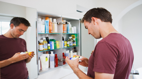Man looking through his medicine cabinet.