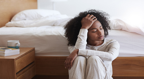 Woman exhausted by the bed.