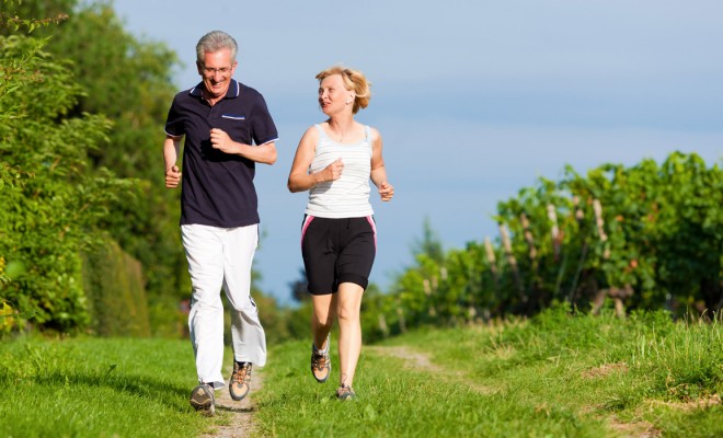 Elderly couple running on a trail.