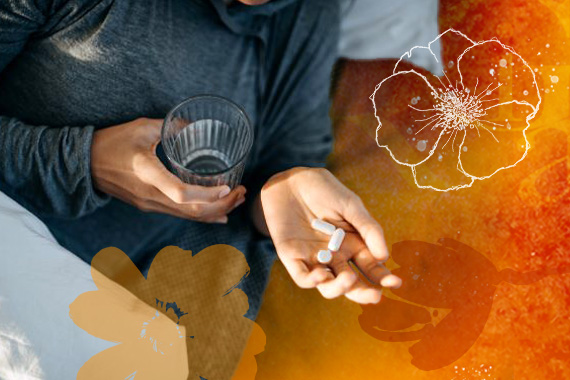 photo of a person with pills in their hand and a glass of water