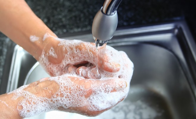 Washing hands with soap and warm water.