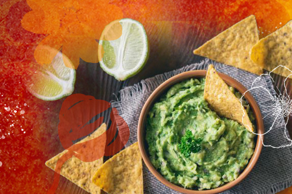 bowl of guacamole with sliced limes and tortilla chips