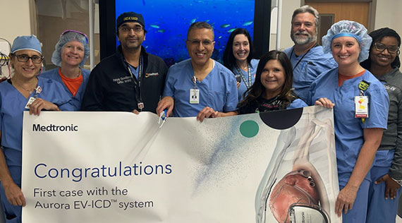 A surgical team holding a banner