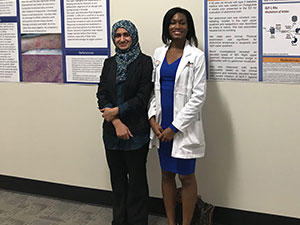 two women standing against a wall