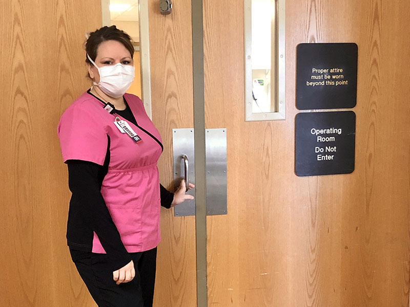 A nurse standing in front of doors