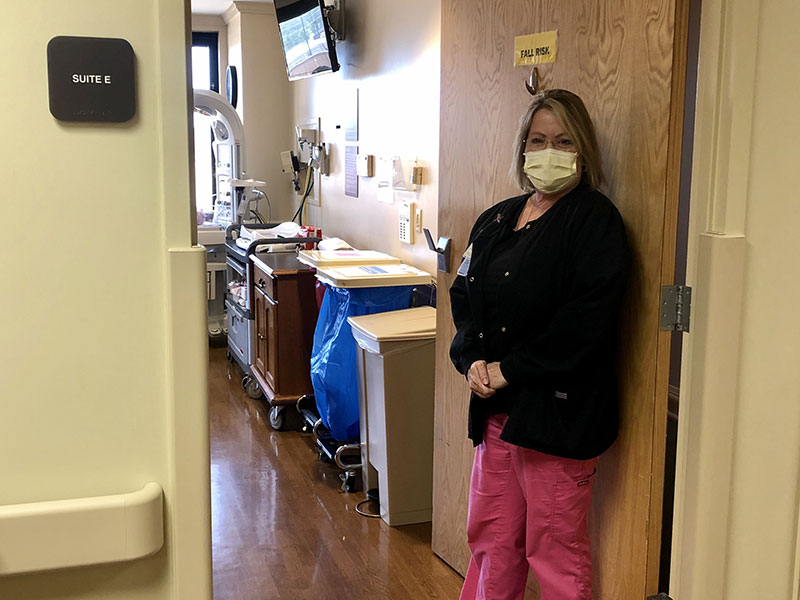 A nurse standing in front of a patient room