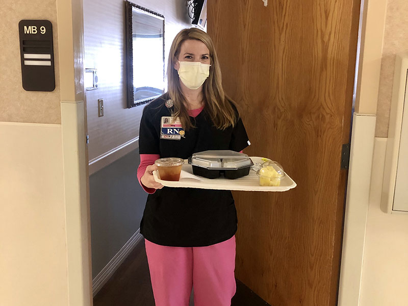 A nurse holding a patient's meal