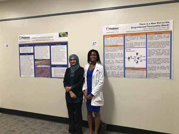 Members of the Piedmont Athens GME team standing in front of a wall