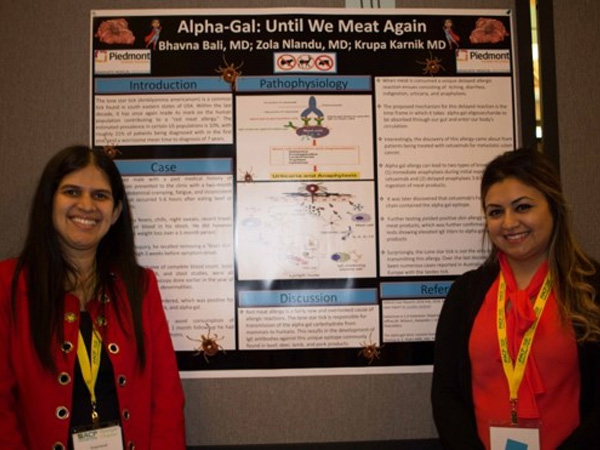 Two women standing in front of a board