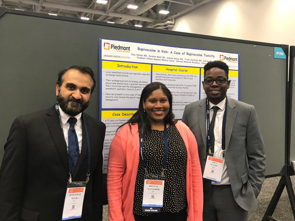 Three people standing in front of a board