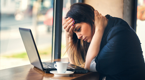 A tired woman at a coffee shop.